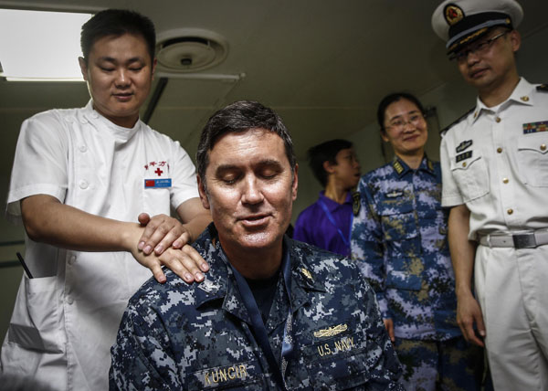 Erik Kuncir, a medical expert with the US navy, enjoys massage treatment by Chinese therapist Gu Wei on June 18 onboard Chinese hospital ship Peace Ark, which visited Brunei for a drill involving a number of countries including China and the United States. ZHANG HAO / FOR CHINA DAILY 