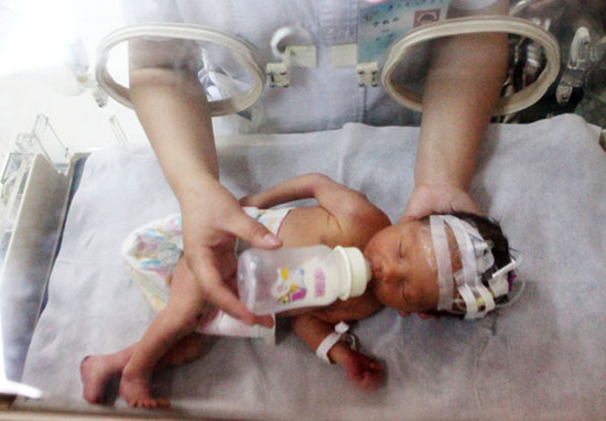 An infant in an incubator receives care at a hospital in Jinhua, Zhejiang province, on Tuesday. The newborn was rescued from a sewer pipe in a residential building last week. Zhong Cheng / for China Daily