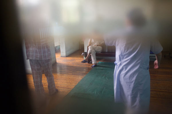 A medical worker helps drug addicts at the Shanghai Huashi Drug Recovery Hospital in Shanghai, June 20, 2013. [Photo by Gao Erqiang/Asianewsphoto]