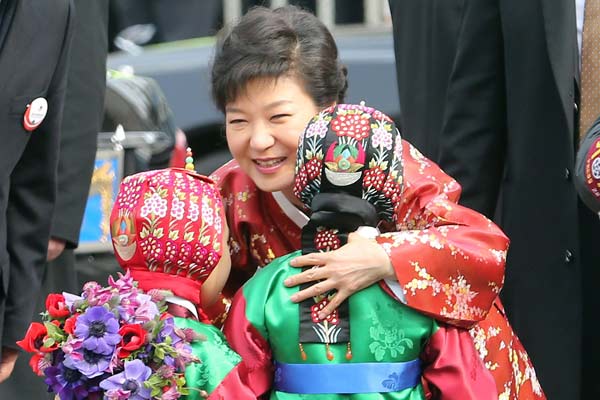 Republic of Korea President Park Geun-hye, wearing a traditional dress, is greeted by two children upon her arrival at the presidential house after her inauguration ceremony as the 18th ROK president in Seoul on Feb 25. Park took office as the ROK's first female president. Suh Myung-gon / Yonhap News Agency via Associated Press 