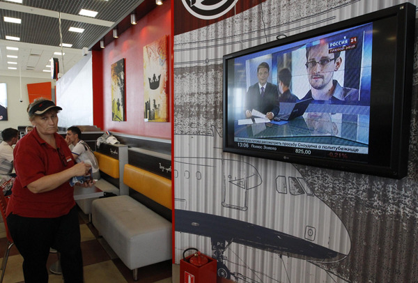 A television screens the image of former US spy agency contractor Edward Snowden during a news bulletin at a cafe in Moscow's Sheremetyevo airport on June 26, 2013. Russian President Vladimir Putin confirmed on Tuesday that Snowden, sought by the United States, was in the transit area of a Moscow airport but ruled out handing him to Washington. [Photo/Agencies] 