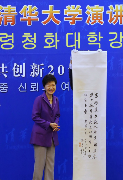 South Korea's President Park Geun-hye stands next to a Chinese calligraphy scroll, which was presented by Tsinghua University, after making her address at the university during her state visit to China in Beijing June 29, 2013. [Xu Jingjing/China Daily]
