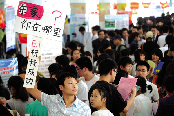 A college graduate holds a placard with Chinese characters that read Where are you, my boss? at a job fair in Bozhou, Anhui province. Zhang Yanlin / for China Daily
