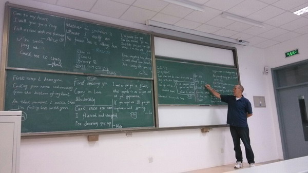 Alex Olah, an English teacher at the Qingdao-based China University of Petroleum, breaks down love poems by his students majoring in International Trade. [Photo provided to China Daily]