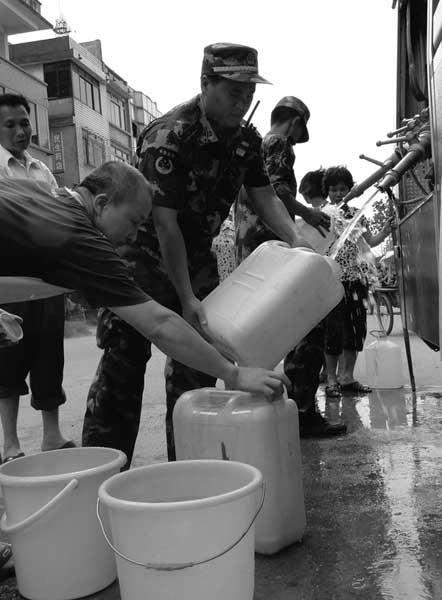 Firefighters from Fengkai county, Guangdong province, provide clean water for residents. Fengkai authorities warned on Saturday that water in a section of the Hejiang River has been tainted by pollution upriver. Wei Shiming / for China Daily 