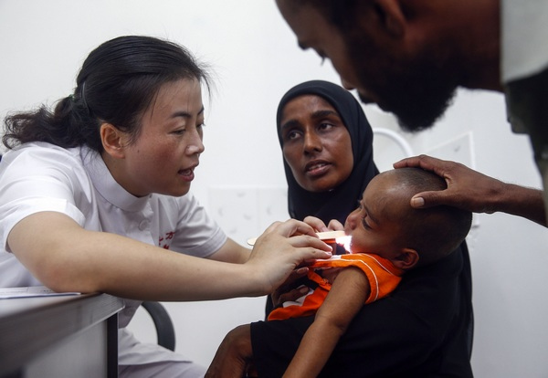 Pediatrician Du Kan checks a child on Eydhafushi in the Maldives. Du is on the hospital ship Peace Ark for an aid mission to Asian and African nations. Zhang Hao / for China Daily