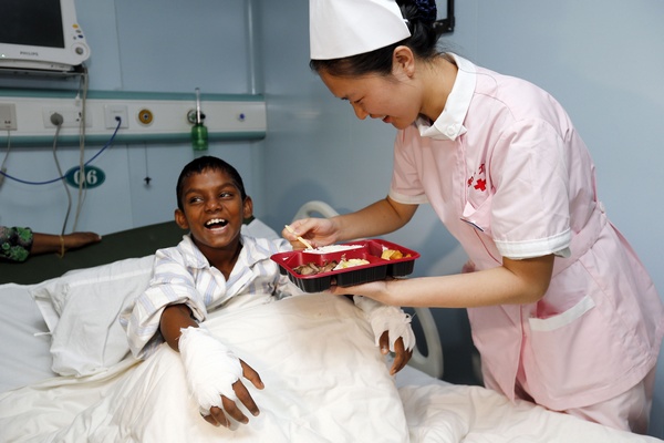 The 10-year-old boy from a care home in the Maldives after undergoing surgery on the Peace Ark to remove two extra fingers on each hand. Photos by Zhang Hao / for China Daily