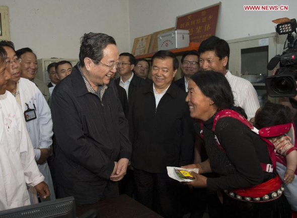 Yu Zhengsheng (center L), a member of the Standing Committee of the Political Bureau of the Communist Party of China (CPC) Central Committee and chairman of the National Committee of the Chinese People's Political Consultative Conference, talks with people of the Tibetan ethnic group at a township hospital in Gannan Tibetan Autonomous Prefecture, northwest China's Gansu Province, July 7, 2013. Yu made an inspection tour in Gannan recently. (Xinhua/Li Xueren)