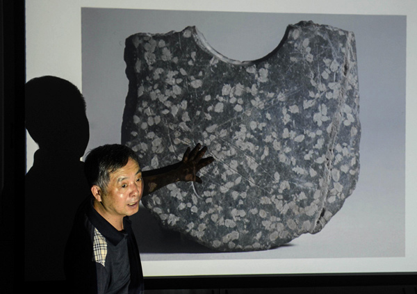 Cao Jinyan, an archaeological expert and a professor in Zhejiang University, introduces the carved symbols. [Photo/Xinhua]