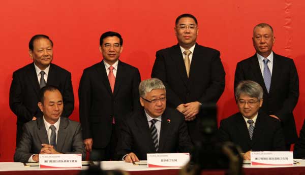 Beijing Mayor Wang Anshun (second from left, back row) and Chui Sai-on (second from right, back row), chief executive of the Macao Special Administrative Region, witness the signing of a slew of agreements between the two cities at the Second Beijing Macao Cooperation and Exchange Symposium on Wednesday. Parker Zheng / CHINA DAILY