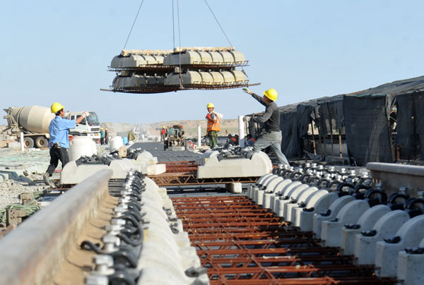Workers unload parts for the ballastless track in Hami, part of the Lanzhou-Urumqi high-speed railway route. The project is scheduled for completion in 2014. Photos by Yao Tong / for China Daily