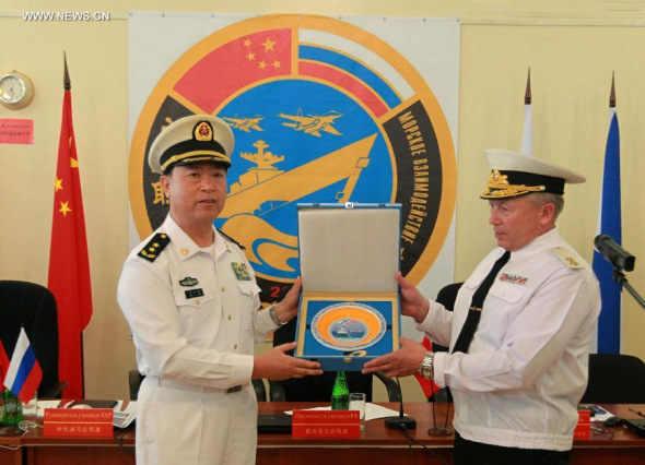 Directors of Joint Sea-2013 drill from China and Russia exchange gifts at the closing ceremony of the joint naval drills in Vladivostok, Russia, July 11, 2013. Ding Yiping, deputy commander of the Chinese Navy and director of the Joint Sea-2013 drill, announced the end of the joint naval drills here on Thursday. (Xinhua/Zha Chunming) 