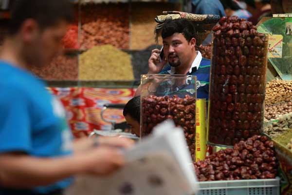 A businessman sells nuts at the Xinjiang International Grand Bazaar in Urumqi on July 11. Cui Meng / China Daily
