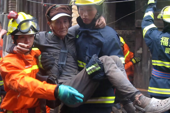 A man is rescued from a house that collapsed on Sunday after Typhoon Soulik dumped 240 mm of rain in the Tongan district of Xiamen, Fujian province. Zeng Demeng / for China Daily