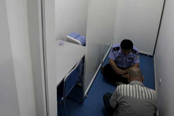 A prisoner undergoes meditative therapy in the company of a correctional officer at Beijing Prison. Wang Jing / China Daily
