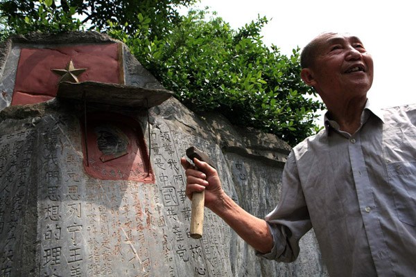 Jiang Jiwei shows his works featuring Chairman Maos quotations at Yulu Hill, in 2008, in Zhutang village of Quanzhou county, Guangxi Zhuang autonomous region.Photos by Huo Yan / China Daily