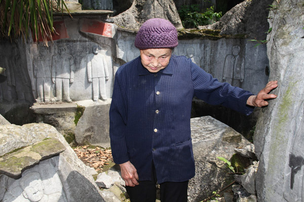 Liu Xiaoying, Jiang Jiweis wife, introduces her husbands works at the foot of Yulu Hill in Zhutang village.