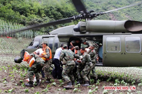 Relief workers unload disaster-relief supplies from a helicopter in Caopo Township of Wenchuan County, southwest China's Sichuan Province, July 16, 2013. The People's Liberation Army (PLA) Chengdu Military Area Command has dispatched helicopters to help with relief work in Wenchuan County which has been affected by flooding. An aviation unit dispatched three helicopters with 19 relief workers and 7.5 tonnes of materials in 12 flights to Caopo Township of Wenchuan County, which suffered downpours and mud-rock flows, according to the area command. (Xinhua/Wu Yongbin)