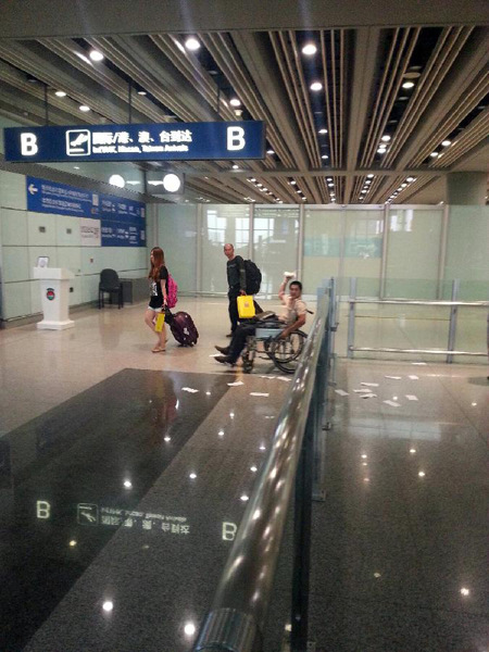 Photo taken on July 20, 2013 with a cellphone shows Ji Zhongxing (man on the wheelchair), suspect of an explosion at Terminal 3 of the Beijing Capital International Airport in Beijing, capital of China. Ji, a 34-year-old from Heze City of east China's Shandong Province, set off a home-made explosive device outside the arrivals exit of the Terminal 3 at around 6:24 p.m. Saturday after he was stopped from handing out leaflets to get attention to his complaints, an initial police investigation showed. Ji suffered no life-threatening injuries and no other injuries were caused. The police cordon at the arrivals exit has been removed, and the airport has begun to resume normal order. (Xinhua) 