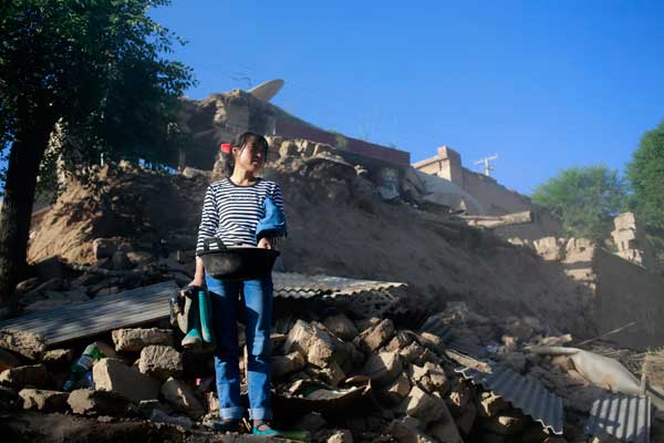 Zong Yuefang, 34, recovers items from the rubble of her home in Minxian.Photos by Feng Yongbin / China Daily 