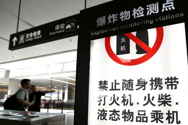 A security staff member at the Shanghai Hongqiao International Airport guides a passenger to the security check on Monday. Security checks were heightened at airports nationwide after a disabled man set off an explosive in Beijing Capital International Airport on Saturday. G SHICHAO / XINHUA