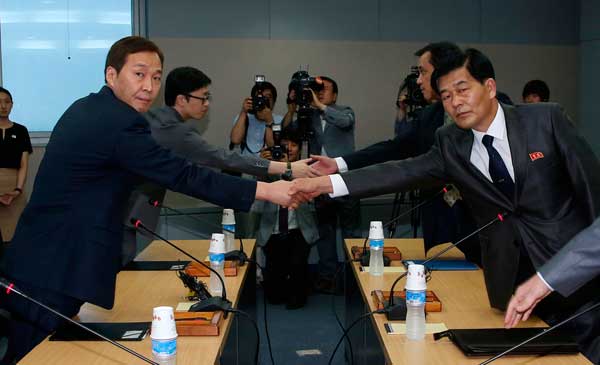 Head of the ROK working-level delegation Kim Ki-woong (left) shakes hands with his DPRK counterpart Park Chol-su during their talks at the Kaesong Industrial District Management Committee in Kaesong on Monday. Yonhap news agency via reuters