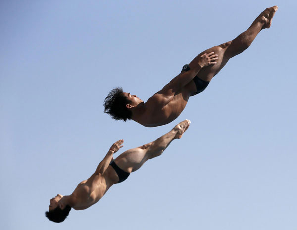 China's Qin Kai and He Chong perform a dive at the men's synchronised 3m springboard preliminary during the World Swimming Championships at the Montjuic municipal pool in Barcelona, July 23, 2013. [Photo/Agencies]