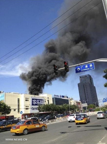 Photo taken by mobile phone on July 24, 2013 shows the smoke from a Carrefour outlet building in Chaoyang District of Beijing, capital of China. Fire broke out at the supermarket around 3:10 p.m. on Wednesday. (Xinhua)