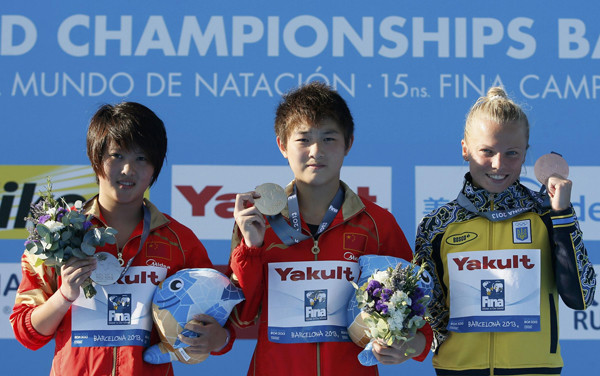 Gold medallist Si Yajie of China (C) poses with her compatriot, silver medallist Chen Ruolin, and bronze medallist Iuliia Prokopchuk (R) of Ukraine at the women's 10m platform victory ceremony during the World Swimming Championships at the Montjuic municipal pool in Barcelona July 25, 2013. [Photo/Agencies]