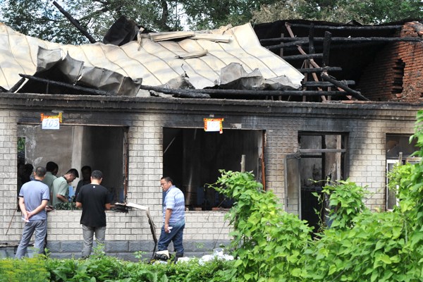Police officers investigate the charred remains of a nursing home in Hailun, Heilongjiang province, where a suspected arson incident killed 11 elderly residents before dawn on Friday. PROVIDED TO CHINA DAILY