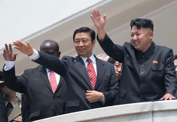 The Democratic People's Republic of Korea (DPRK)'s leader Kim Jong-Un (R) and China's Vice-President Li Yuanchao (C) wave to the crowd during a military parade at Kim Il-Sung square marking the 60th anniversary of the Korean war armistice in Pyongyang on July 27, 2013. [Photo/Agencies]