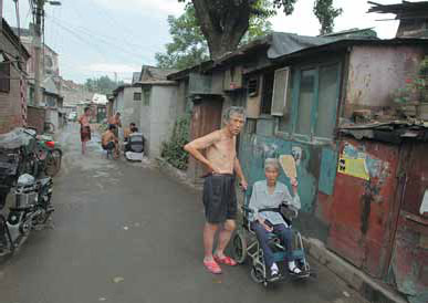 Residents try to keep cool in Xitang, in the Dongcheng district of Beijing, on Sunday. Beijing plans to spend 500 billion yuan ($81.5 billion) to renovate shantytowns like Xitang inside the Fourth Ring Road. The five-year plan includes 527 projects, 83 by the first year. Wang Jing / China Daily