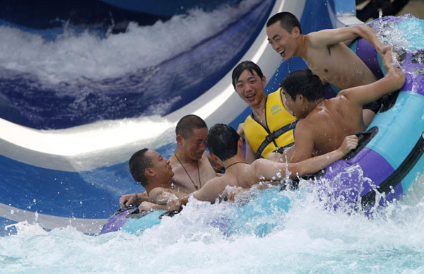 Tourists stay in a water park to keep cool in Shanghai on July 28 as temperatures in the city surpassed 39 degrees Celsius. [Photo/Xinhua]
