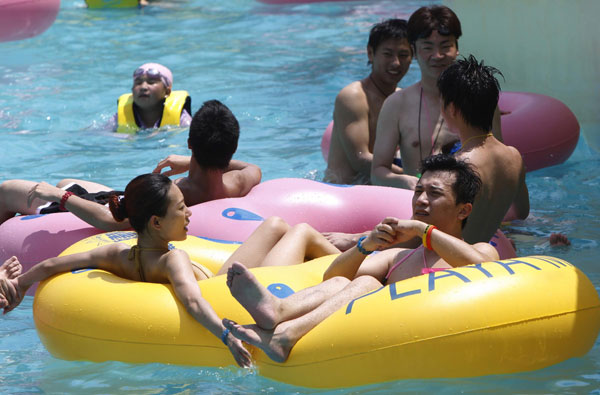 Tourists stay in a water park to keep cool in Shanghai on July 28 as temperatures in the city surpassed 39 degrees Celsius. [Photo/Xinhua] 