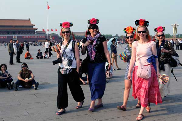 Tourists at Tian'anmen Square attract attention with their Manchu-style headwear in May. PROVIDED TO CHINA DAILY