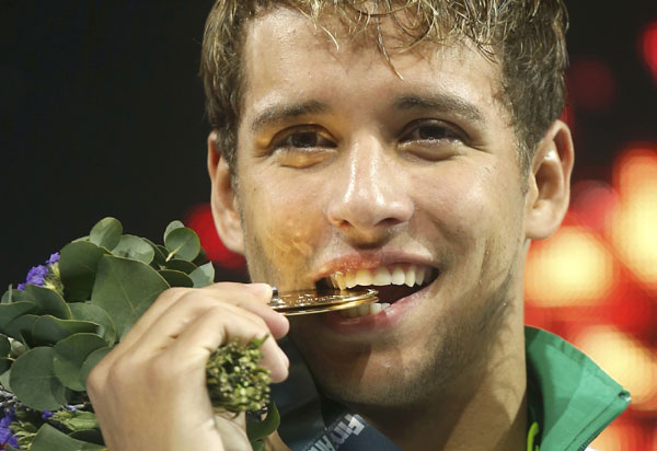 South Africa's Chad le Clos bites his gold medal at the men's 200m butterfly victory ceremony during the World Swimming Championships at the Sant Jordi arena in Barcelona, July 31, 2013. [Photo/Agencies]