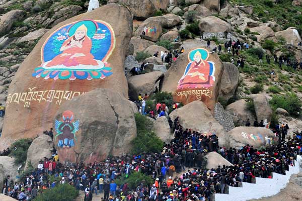 Giant thangka, religious silk embroideries and paintings, on the mountains behind Drepung Monastery in Lhasa, capital of the Tibet autonomous region, attract thousands of people on Tuesday to mark the traditional Shoton Festival.[Photo by Li Zhou / For China Daily]