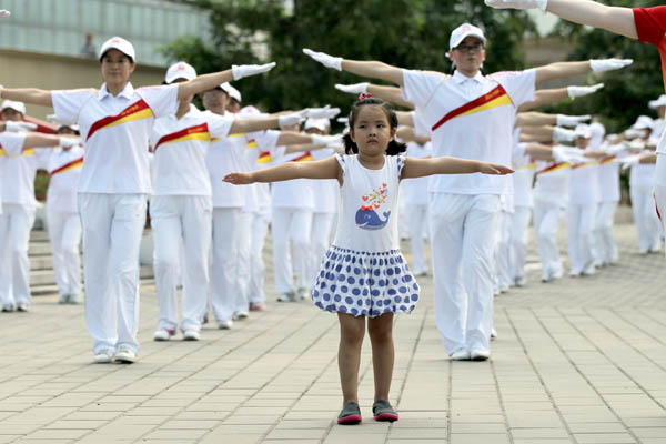Beijing residents do aerobics at the Olympic Sports Center on Thursday. More than 6,500 participants in the capital took part in this year's event for the National Fitness Day. Wang Jing /China Daily