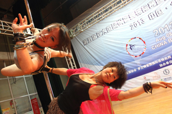 Ding Yi (right), 54, and her daughter Lin Mu, 29, perform on the sidelines of the Seventh China Pole Dance Championships in Beijing on Friday. Both took home a gold medal. ZHANG WEI / CHINA DAILY