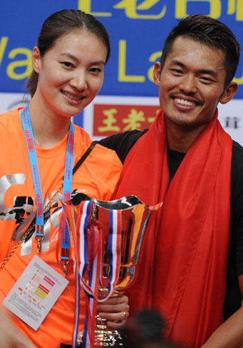 Lin Dan, right, celebrates with his wide Xie Xingfang after winning his fifth world champion during Badminton World Championship final in Guangzhou, Guangdong province, Aug 11, 2013. [Photo/Xinhua] 