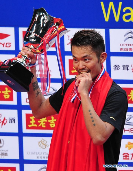 Lin Dan of China reacts during the medal presenting ceremony after men's single final match against Lee Chong Wei of Malaysia at the 2013 BWF World Championships in Guangzhou, capital of south China's Guangdong Province, Aug. 11, 2013. Lin Dan claimed the title as Lee Chong Wei retired in the match. (Xinhua/Bai Xuefei)