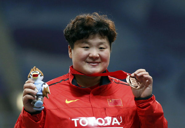 Third placed Gong Lijiao of China shows her bronze medal at the victory ceremony for the women's shot put final during the IAAF World Athletics Championships at the Luzhniki stadium in Moscow, Aug 12, 2013. [Photo/Agencies]