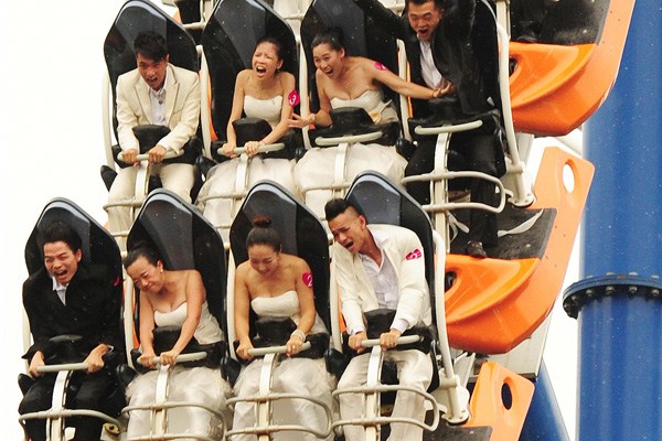 After taking the plunge with a mass wedding at a Shenzhen theme park on Tuesday, the newlyweds celebrate on a roller coaster. According to a matchmaking website, there are about 180 million single people in China of marrying age.CHEN WEN / FOR CHINA DAILY