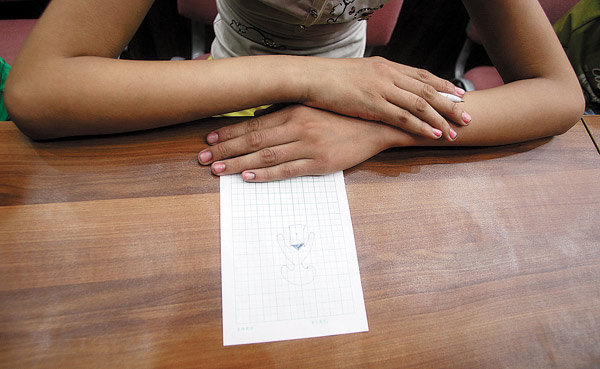 A child participates in a sex education class by drawing a picture at a primary school in Jinan, capital of Shandong province. The class is part of a course aimed at alerting children to the dangers of sexual assault. Zheng Tao / China Daily