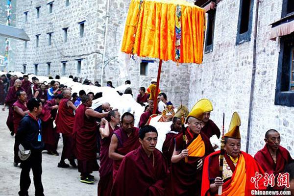 Monks carry the gigantic Buddha Tangka to the unfolding ceremony.