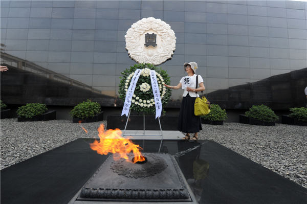 A Japanese woman attends an assembly to mourn for victims in the tragic Nanjing Massacre at the Memorial Hall of the Victims in the Nanjing Massacre by the Japanese Invaders in Nanjing, capital of East China's Jiangsu province, Aug 15, 2013. [Photo/Xinhua]