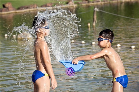 Boys play it cool at Lingshi Park Thursday. Temperatures are set to dip in the city over the next few days. 