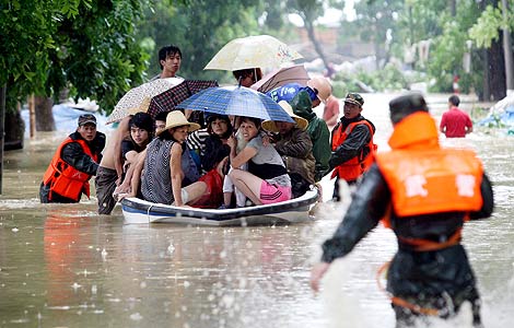 Rescuers help people affected by the typhoon move to a safer place in Wuchuan, Guangdong province, Aug 16, 2013. [Photo/Xinhua]