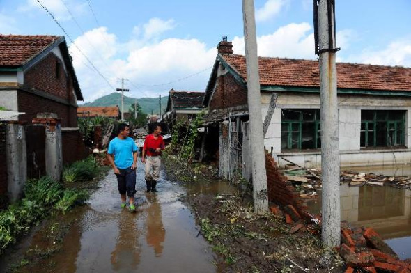 Local residents check the condition of houses in Hongshi Town of Huadian City, northeast China's Jilin Province, Aug. 17, 2013. Fourteen people were killed in the flood that inundated a residential compound on Friday morning. Rescuers have been sent to the flood-hit area. (Xinhua/Xu Chang)  