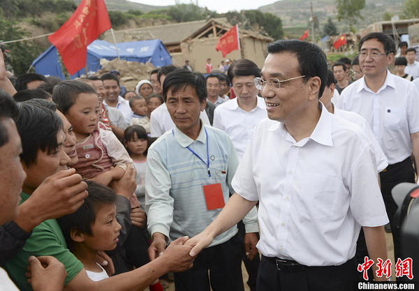 Chinese Premier Li Keqiang shakes hands with a villager upon his arrival at Yongguang village, Minxian county in Northwest China's Gansu province, Aug 17. The village was among the worst-hit areas during the magnitude-6.6 earthquake in the province on July 22. Li visited the village on Saturday for inspection of post-quake construction and resettlement progress of the quake victims. [Photo/Chinanews.com]